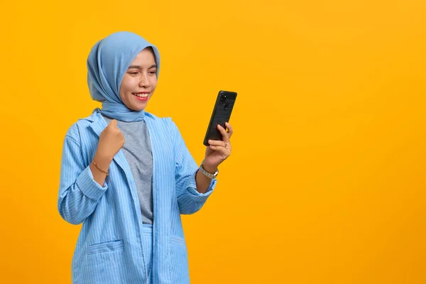 Vrolijke Jonge Aziatische Vrouw Zoek Naar Mobiele Telefoon Geïsoleerd Gele — Stockfoto