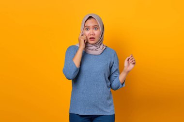 Şaşırmış Asyalı kadının portresi sarı arka planda ağzı açık yeni bir düşünce keşfediyor.
