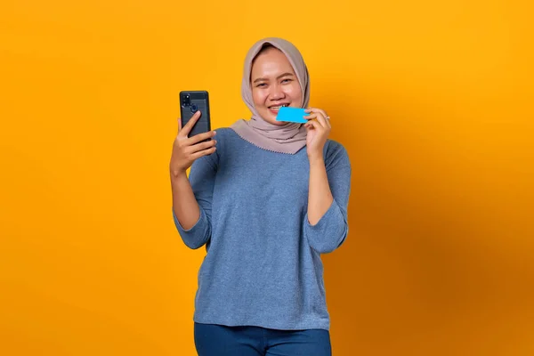 Heyecanlı Asyalı Kadın Akıllı Telefon Tutuyor Sarı Arka Planda Kredi — Stok fotoğraf