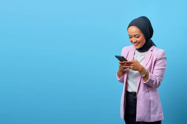 Attraktive Asiatin Benutzt Handy Mit Leerraum Vor Blauem Hintergrund — Stockfoto