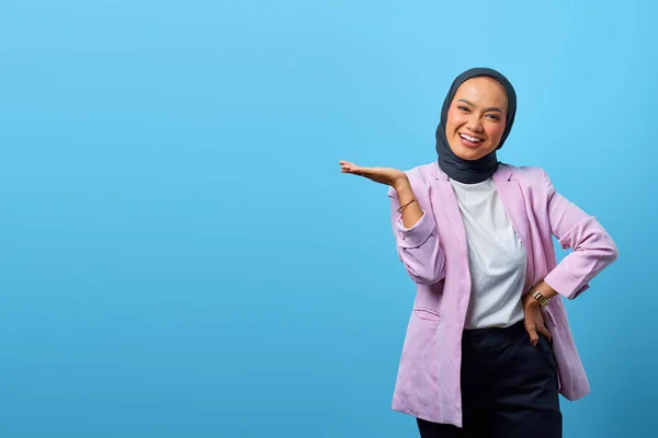 Mulher Asiática Alegre Mostrando Produto Sobre Fundo Azul — Fotografia de Stock