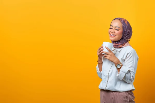 Güzel Asyalı kadın portresi gülümseyen ve elinde boş bir arkaplan olan fincanı tutan.