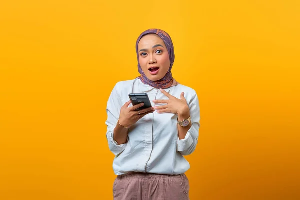 Sarı Arka Planda Ağzı Açık Cep Telefonu Kullanan Şaşırmış Asyalı — Stok fotoğraf