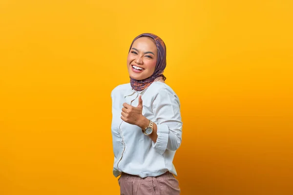 亚洲女人在黄色背景下竖起大拇指的快乐画像 — 图库照片