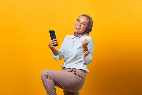 Spännande Asiatisk Kvinna Som Håller Mobiltelefon Firar Lycka Över Gul — Stockfoto