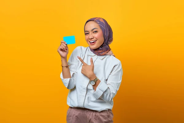 Lächelnde Asiatin Zeigt Gestikulierenden Finger Auf Gelbem Hintergrund — Stockfoto