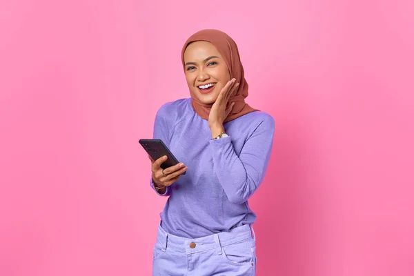笑顔の若いアジアの女性の肖像ピンクの背景に携帯電話を保持 — ストック写真