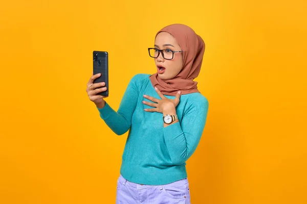 Schockiert Blickt Junge Asiatin Auf Smartphone Bildschirm Auf Gelbem Hintergrund — Stockfoto