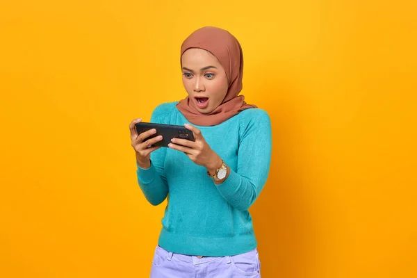 Şok Olmuş Genç Asyalı Kadın Sarı Arka Planda Akıllı Telefondan — Stok fotoğraf