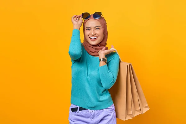 Sonriente Joven Asiática Sosteniendo Bolsas Compras Quitarse Gafas Sobre Fondo —  Fotos de Stock