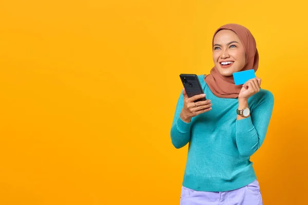 Lächelnde Junge Asiatin Mit Kreditkarte Und Smartphone Auf Gelbem Hintergrund — Stockfoto