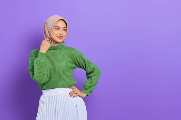 美しい笑顔アジアの女性で緑のセーターに手を取ります上のヒップ 離れて見ますコピースペース隔離された上に紫の背景 — ストック写真