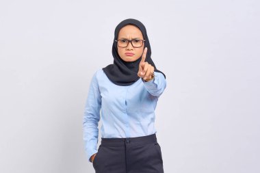 Beyaz arka planda izole edilmiş dur hareketi gösteren ciddi bir Asyalı genç kadın portresi