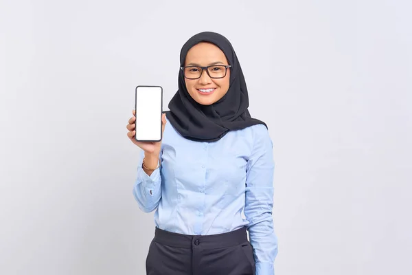笑顔の若いアジアの女性の肖像画は 空白の画面の携帯電話を示しており 白い背景に隔離されたカメラを見て — ストック写真