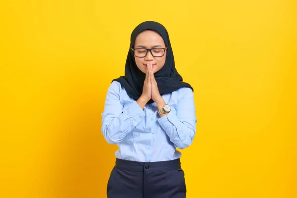 Sarı Arka Planda Gözleri Kapalı Dua Eden Güzel Asyalı Genç — Stok fotoğraf