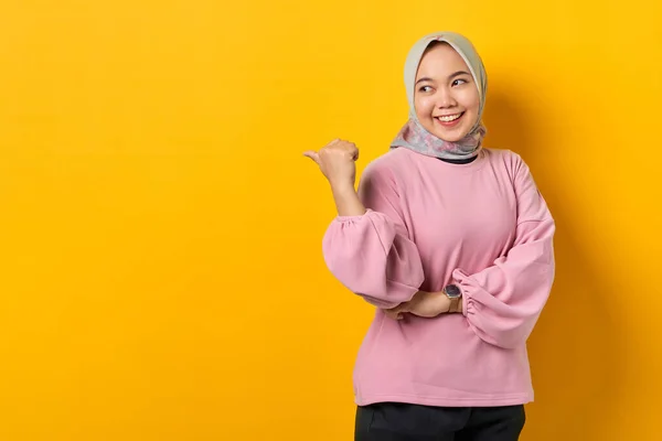 陽気若いですアジアの女性でピンクシャツPointing指でコピースペース上の黄色の背景 — ストック写真