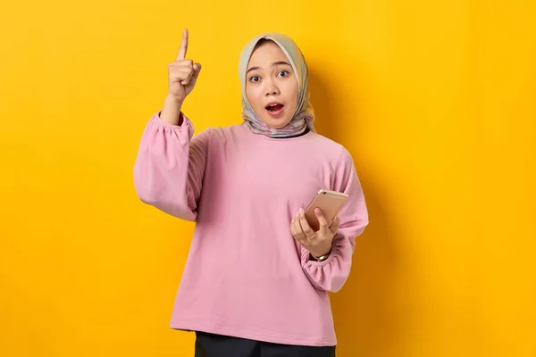 Mujer Asiática Joven Asombrada Camisa Rosa Sosteniendo Teléfono Móvil Señalando —  Fotos de Stock
