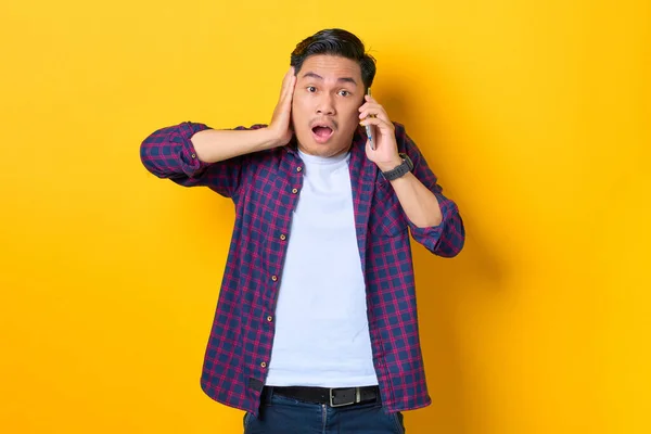 Shocked Joven Asiático Hombre Camisa Cuadros Hablando Teléfono Móvil Aislado — Foto de Stock