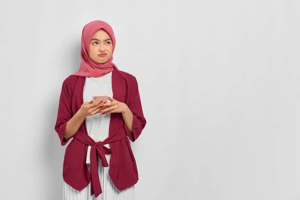 Запутавшаяся Красивая Азиатка Повседневной Рубашке Хиджабе Используя Мобильный Телефон Смотрит — стоковое фото