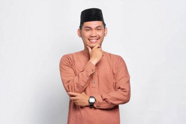 Genç Asyalı Müslüman gülümseyen ve kendinden emin görünen adam beyaz arka planda izole edilmiş.