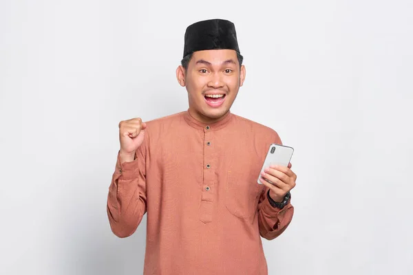 Excited Young Asian Muslim Man Using Mobile Phone Celebrating Success — Stock Photo, Image