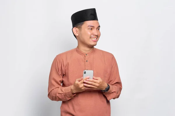Leende Ung Asiatisk Muslim Man Med Hjälp Mobiltelefon Och Tittar — Stockfoto