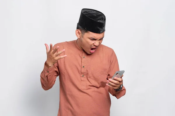 Rozzlobený Mladý Asijský Muslim Muž Pomocí Mobilního Telefonu Zatímco Hlasitě — Stock fotografie