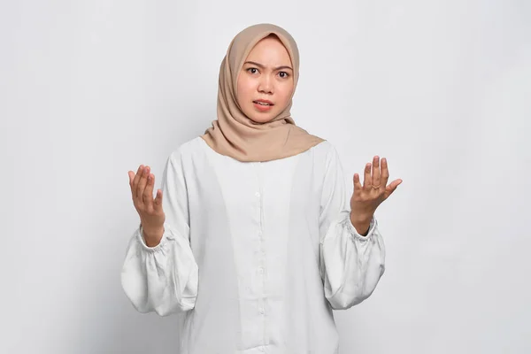 混乱したアジア系イスラム教徒の女性は手を横に広げ 白い背景の上に隔離された選択をしながら疑いを感じる — ストック写真