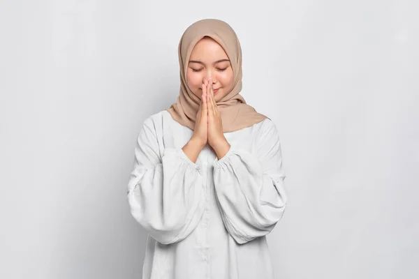 白い背景の上に隔離された口の近くで祈りの手を持つアジア系ムスリム女性の肖像 — ストック写真