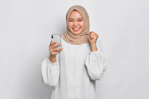 Nadšený Mladý Asijský Muslim Žena Pomocí Mobilního Telefonu Slaví Úspěch — Stock fotografie
