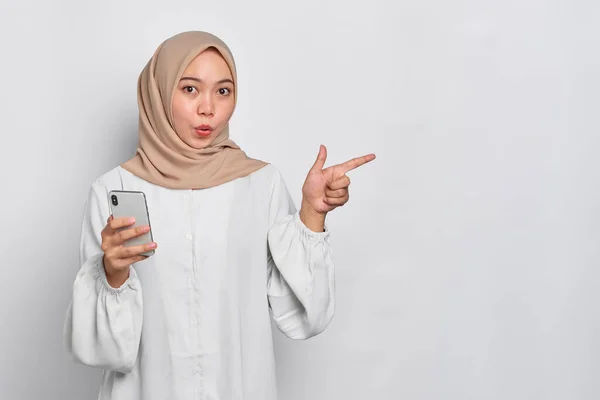 Verblüffte Junge Asiatische Muslimin Hält Handy Der Hand Und Zeigt — Stockfoto