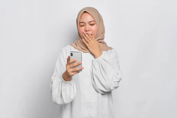 Zdezorientowany Młody Azji Muzułmanin Kobieta Trzyma Telefon Komórkowy Uczucie Senności — Zdjęcie stockowe