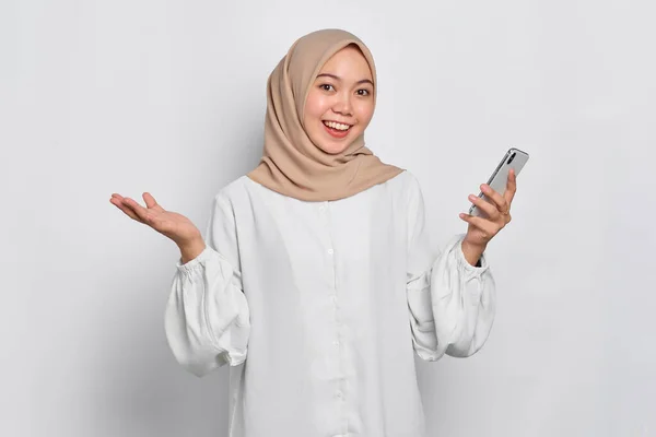 携帯電話を使用して興奮した若いアジアのイスラム教徒の女性と成功を祝う 白い背景に隔離された良いニュースを取得 — ストック写真