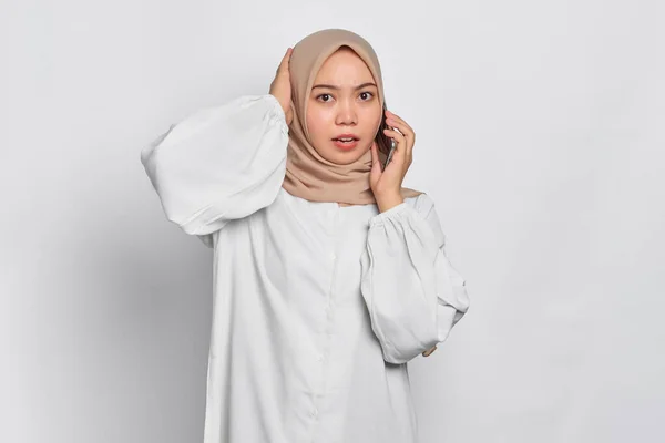 Μπερδεμένη Νεαρή Ασιάτισσα Μουσουλμάνα Που Μιλάει Στο Κινητό Τηλέφωνο Απομονωμένη — Φωτογραφία Αρχείου