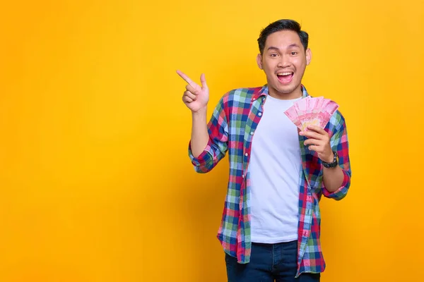 Amazed Young Asian Man Plaid Shirt Holding Money Banknotes Pointing — ストック写真