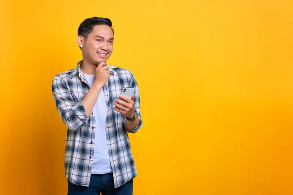 Χαρούμενος Νεαρός Ασιάτης Καρό Πουκάμισο Κρατώντας Κινητό Του Τηλέφωνο Και Φωτογραφία Αρχείου