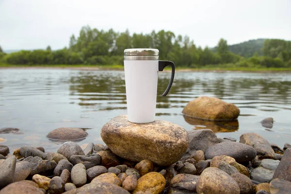 White travel coffee mug mockup with stony river bottom. Empty mug mock up for design promotion.