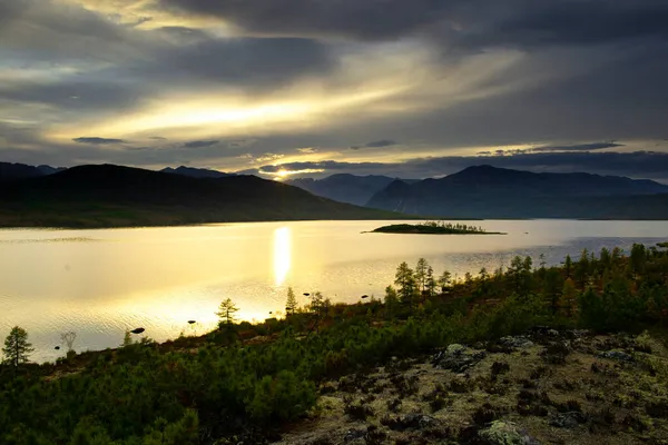 - Rusya. Magadan Bölgesi. Büyük Anngachak dağ sırasının arka planına karşı güzel bir orman gölü. Jack London Gölü civarlarında sonbahar.