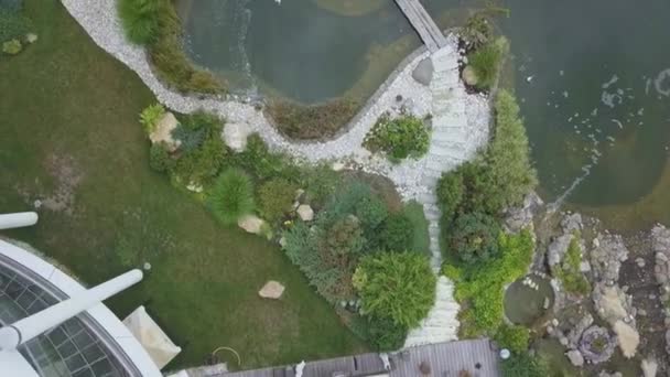 Bovenaanzicht van aangrenzend grondgebied van het land herenhuis met patio en kunstmatige vijver in de zomer dag — Stockvideo