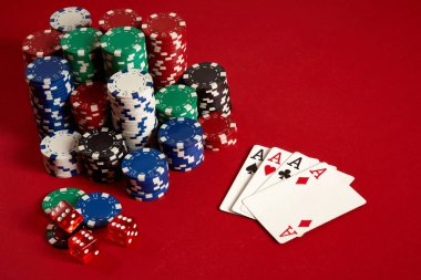Kumarhane kumarhanesi poker ekipmanları ve eğlence konsepti. Kırmızı arka planda kart ve fiş oyunlarının kapanışı. Türünün Dörtlü