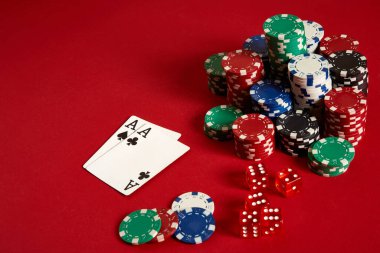 Poker fişleri ve kırmızı zemin üzerine as. Farklı poker fişleri grubudur. Casino arka plan.