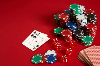 Poker fişleri ve kırmızı zemin üzerine as. Farklı poker fişleri grubudur. Casino arka plan.
