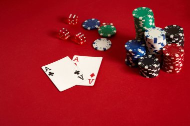 Poker fişleri ve kırmızı zemin üzerine as. Farklı poker fişleri grubudur. Casino arka plan.