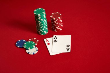 Poker fişleri ve kırmızı zemin üzerine as. Farklı poker fişleri grubudur. Casino arka plan.
