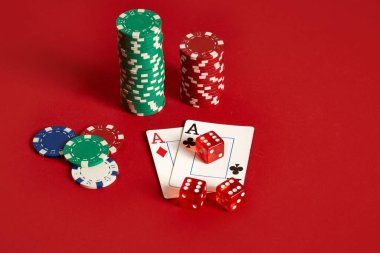 Poker fişleri ve kırmızı zemin üzerine as. Farklı poker fişleri grubudur. Casino arka plan.