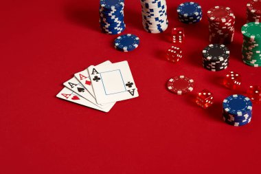 Kumarhane kumarhanesi poker ekipmanları ve eğlence konsepti. Kırmızı arka planda kart ve fiş oyunlarının kapanışı. Türünün Dörtlü