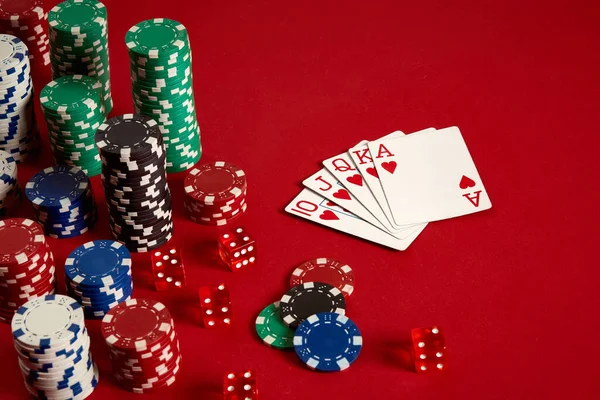Kumarhane kumarhanesi poker ekipmanları ve eğlence konsepti. Kırmızı arka planda kart ve fiş oyunlarının kapanışı. Kraliyet floş kalbi.. — Stok fotoğraf