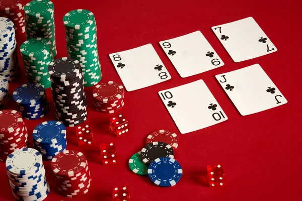 Casino gambling poker equipment and entertainment concept - close up of playing cards and chips at red background. Straight Flush — Stock Photo, Image