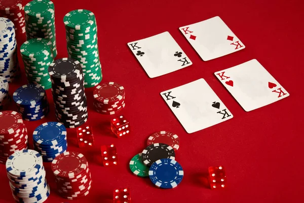Casino gambling poker equipment and entertainment concept - close up of playing cards and chips at red background. Four of a Kind — Stock Photo, Image