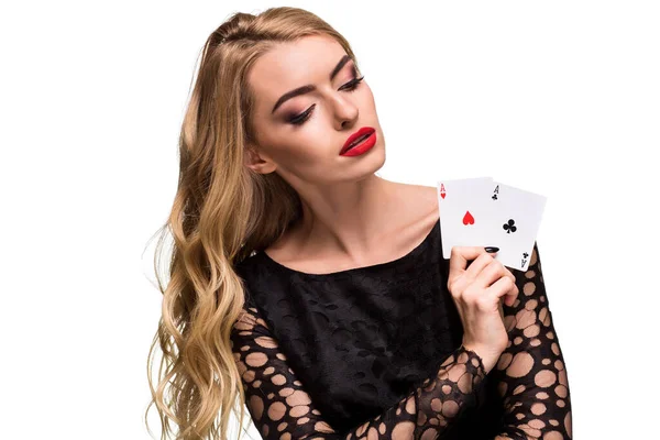 Hermosa joven sosteniendo dos as de cartas en su mano aisladas sobre fondo negro — Foto de Stock